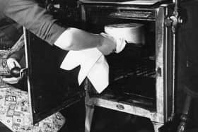 A housewife baking a cake in her oven in 1949