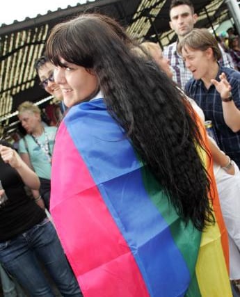 A woman wearing a pride flag in 2009.