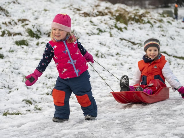 Jessica Pike 3, pulls her sister Ellie 5 on a sledge in Holyrood Park