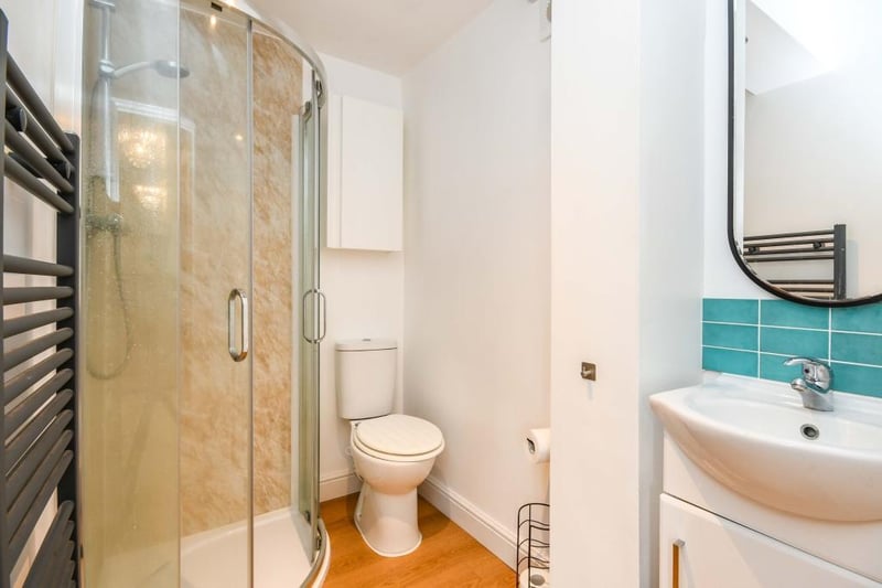 The ensuite from the third bedroom has a heated towel rail, panelled walls, extractor fan, LVT flooring and a handy built-in cupboard. There is a three piece suite with a single shower, low-flush WC and a vanity sink with a mixer tap.