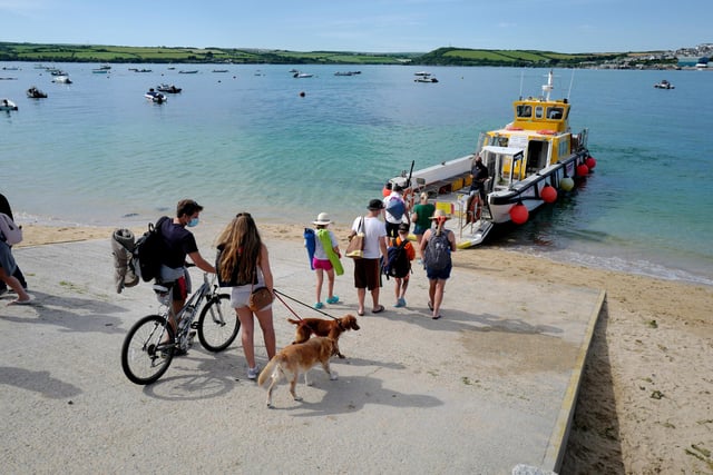 Holidaymakers are seen here waiting for the Rock to Padstow ferry in Cornwall - Padstow is a working fishing port as well as a destination for foodies thanks to its association with celebrity chef Rick Stein.