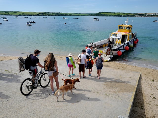 Holidaymakers are seen here waiting for the Rock to Padstow ferry in Cornwall - Padstow is a working fishing port as well as a destination for foodies thanks to its association with celebrity chef Rick Stein.