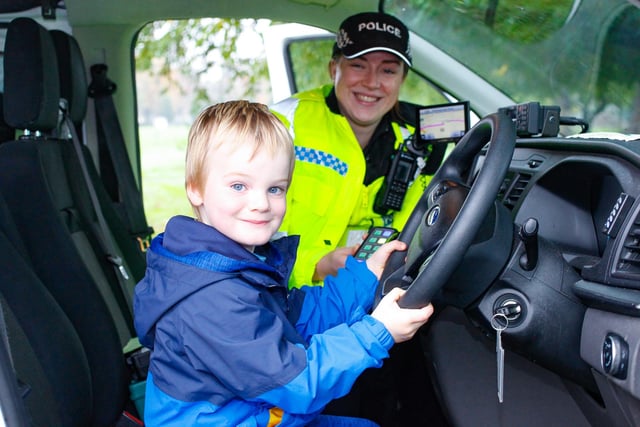 Aaron Muir (4) stays dry with Community Officer Pacitti during the rainy sporting activity day