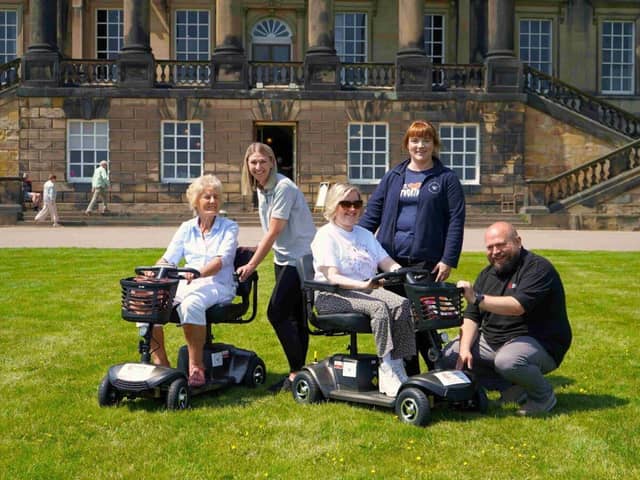 Wentworth Woodhouse visitor Hilary Bullock (left), 85, of Dronfield, and Lucy Nadin, the Trust’s Front of House officer, put the new scooters to the test on the mansion’s East Front. Also pictured LtoR: Clark & Partners sales and marketing director Debbie Ashton, WWPT employee Liz North, Clark & Partners product specialist Martin Elrick 