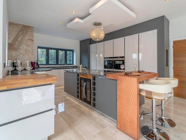 A wonderful open-plan kitchen diner and living space, 40 feet in length, is a highlight of the property. The bespoke German kitchen features a fully integrated wi-fi-enabled Siemens double oven, induction hob, fridge and freezer, AEG dishwasher, copper breakfast bar, Klarstein wine cooler and champagne trough..