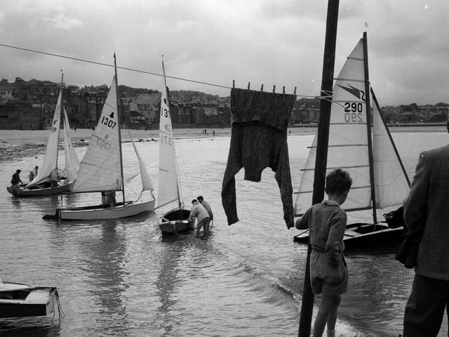 A little boy watches adults leave North Berwick Harbour in their dingy in July 1962.