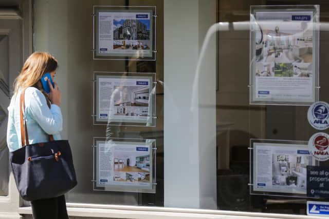 A woman looks at adverts in the window of an estate agent. Picture: DANIEL LEAL-OLIVAS/AFP via Getty Images.