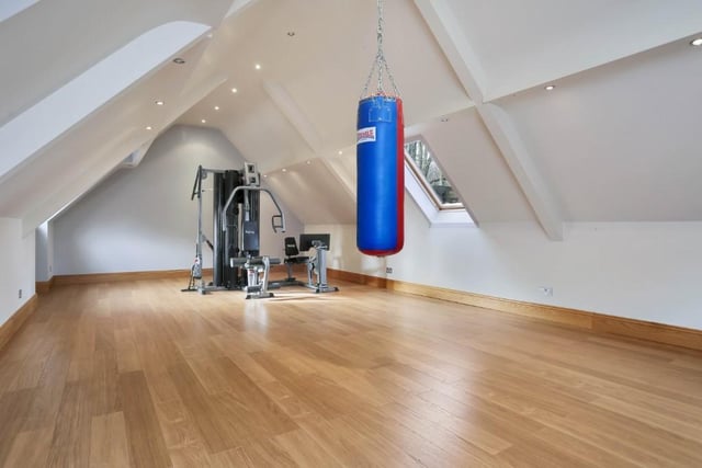 The large, detached garage has room for five cars, plus its own alarm system, storage space and a bespoke shed. On its first floor is this large and versatile room that is currently being used as a gym.