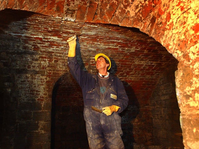 Constuction workers getting the gatehouse to the General Cemetery ready for its opening in 2012. Bricklayer John Shultz pointing inside the catacomb underneath the gatehouse.