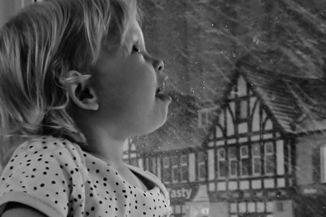 Two-year-old Isla Devena Hopkins watches with amazement as the snow falls in Easington Lane.