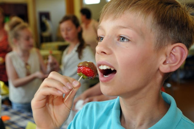 Brogan Malone sinks his teeth into a chocolate strawberry at St Teresa's Summer Fair in Hartlepool seven years ago.