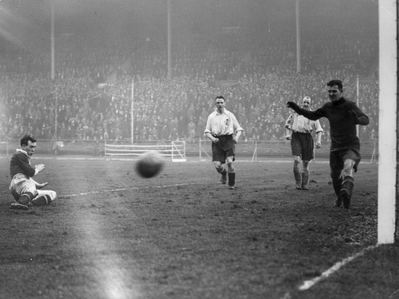 Hughie Gallacher, grounded leftl has an attempt on goal with Ted Hufton happy to see it go wide