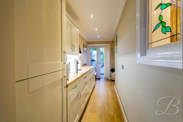 This narrow, elongated section is part of the quirkily-shaped kitchen. At one end are patio doors leading to the back garden, while at the other is a door leading to the front of the property.