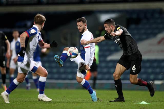 Adam Armstrong of Blackburn Rovers plays a ball through under pressure from Richard Wood of Rotherham United.