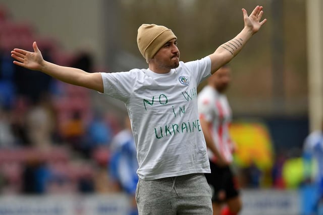 A Wigan fan makes a statement on the pitch.
