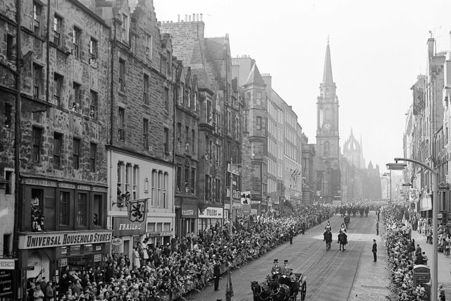Another picture of the royal coach containing Queen Elizabeth II and King Olav of Norway proceeding down the Royal Mile in a spectacular procession in 1962.