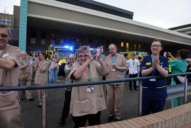 Ambulances can be seen flashing their blue lights behind NHS workers during Clap for Carers.
