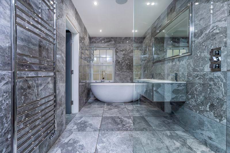 Four-piece bathroom comprising wet-room style shower, double ended bath, twin basins and WC.