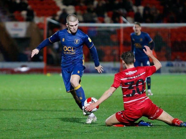 Mansfield Town midfielder Ryan Stirk gets past Ben Blythe.