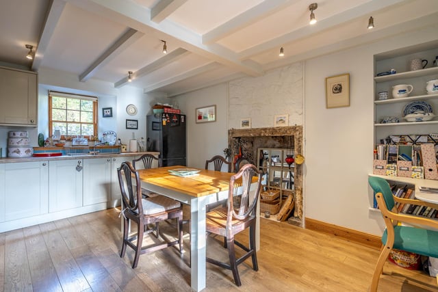 Original ceiling beams and a feature fireplace add period appeal in the kitchen