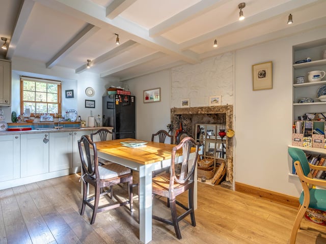 Original ceiling beams and a feature fireplace add period appeal in the kitchen