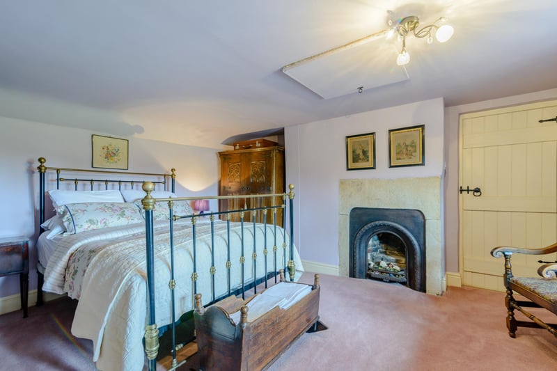 The principal bedroom has an exposed stone fireplace with a Victorian ornamental cast iron inset.