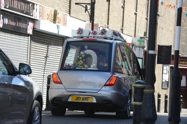 Scores of floral tributes, including one from her children, filled the funeral car.