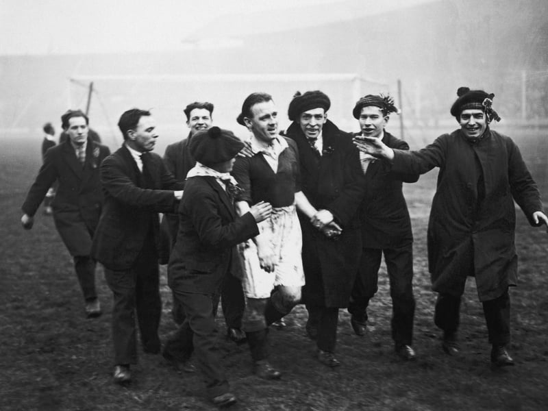 Scotland fans escorting captain Jimmy McMullan from the pitch at Wembley after Scotland had beaten England 5-1.