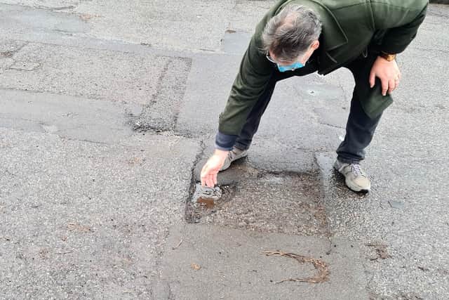 Councillor Peter Garbutt inspecting the pot holes at Nether Edge