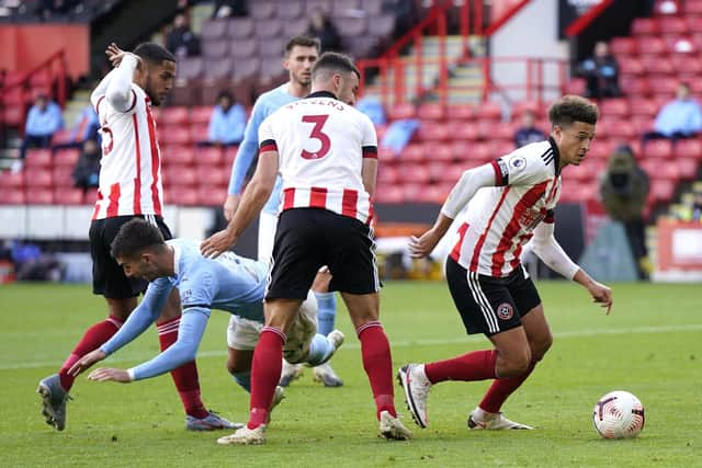 Manchester City's Ferran Torres (second left) goes down as Sheffield United's Ethan Ampadu comes away with the ball during the Premier League match at Bramall Lane: Tim Keeton/PA Wire.