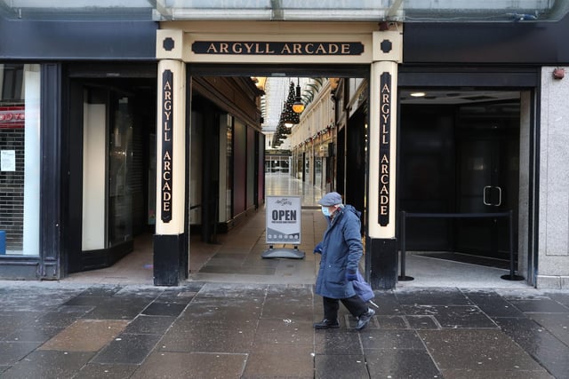 A man wearing a face mask walks past the entrance to Argyll Arcade in Glasgow city centre