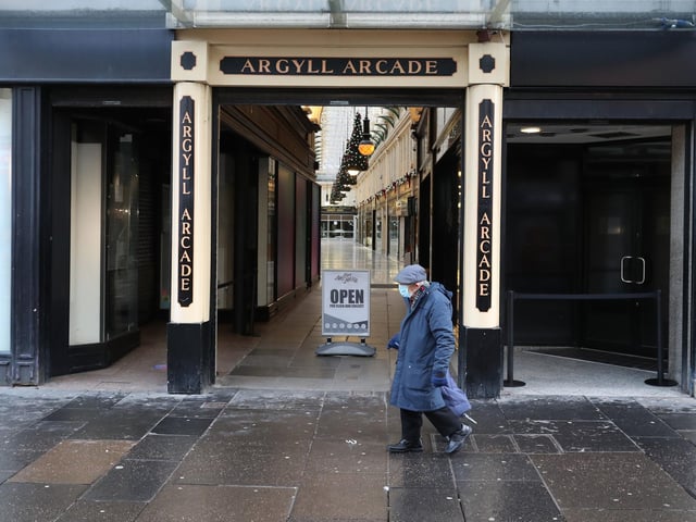 A man wearing a face mask walks past the entrance to Argyll Arcade in Glasgow city centre
