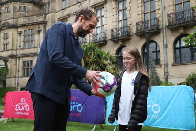 England manager Gareth Southgate hands over a signed football to a young fan. (Photo by Jan Kruger - The FA/The FA via Getty Images)