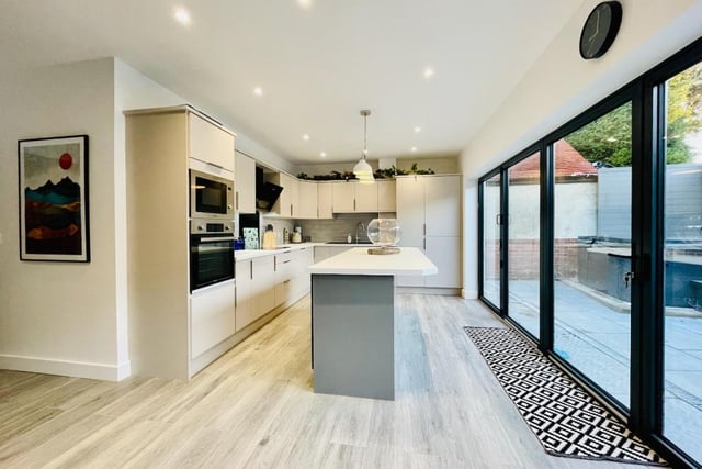 The stunning open plan, living kitchen with bi-folding doors leads out to the rear patio with hot tub.