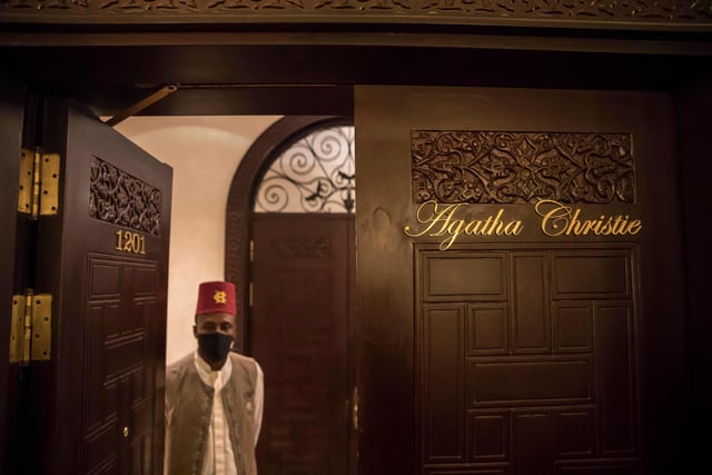 An employee (mask-clad due to the COVID-19 coronavirus pandemic) of the Old Cataract Hotel stands through the door of the suite where British crime fiction writer Dame Agatha Christie is believed to have stayed while writing her 1937 novel "Death on the Nile",