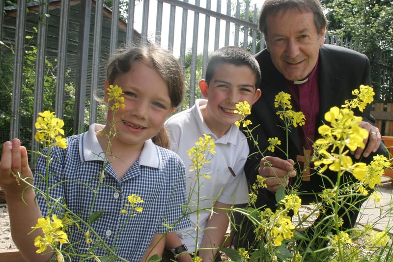 Calow primary pupils Maisy Ainsworth and Jacob Bloor enjoy the schools new garden with Bishop of Derby Alastair Redfern.