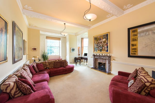 This is a bright and spacious drawing room with an open fire.