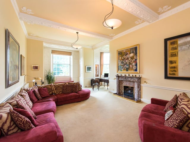 This is a bright and spacious drawing room with an open fire.
