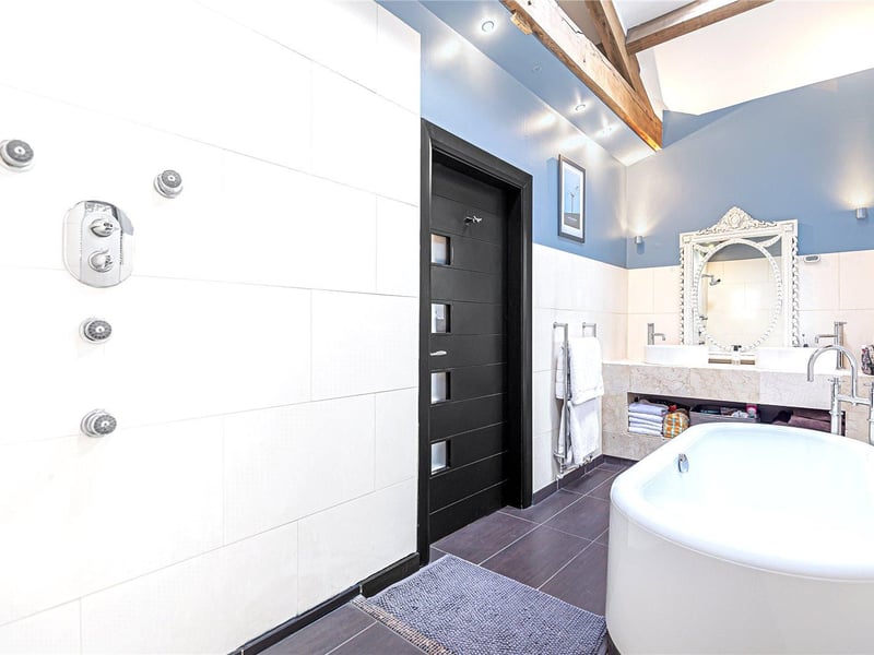 All four bedrooms in the property benefit from their own en-suite facilities, with the master enjoying this modern suite with dual sinks, bathtub and shower.