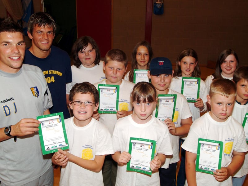 Mansfield Town youth team manager David Jervis, left, and captain Ashley Kitchen present Community Sports certificates to Queen Elizabeth pupils who took part in a summer school.