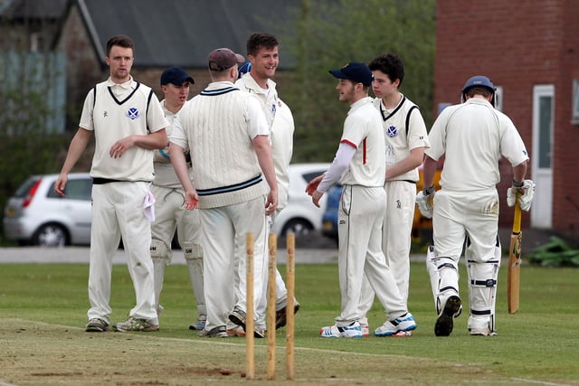 Hadfield's Rick Trunter (middle) celebrates taking the first wicket against New Mills in April 2015.