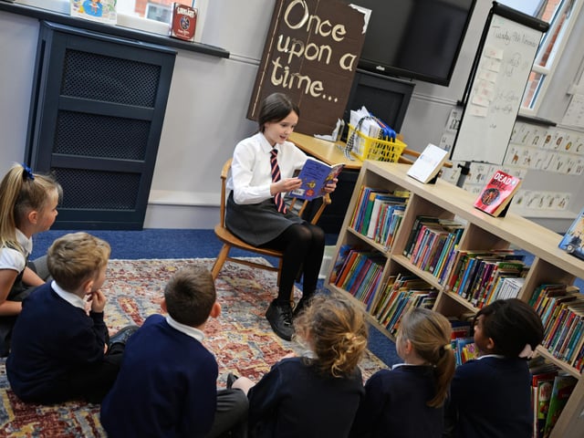 Year Two children sit on the Magic Carpet as a year six pupil reads them a story in the Snug. Picture: NDFP-09-11-21-StAlbans 2-NMSY