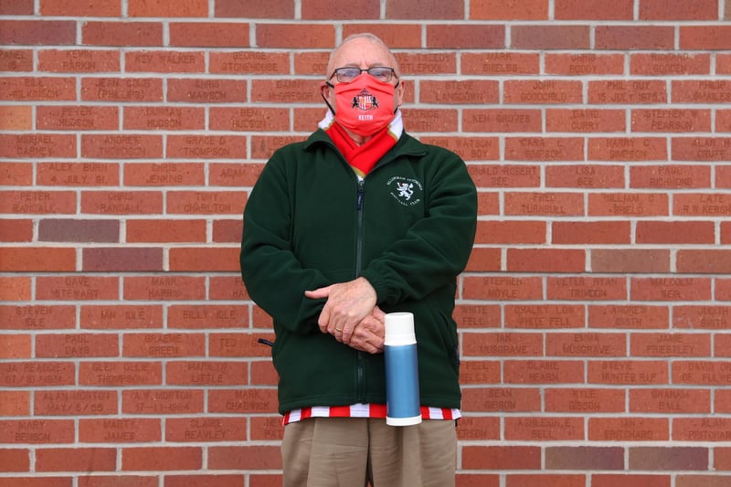 A Sunderland fan wearing a face mask waits to enter the stadium.