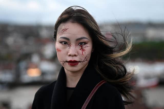 A participant in costume poses for a photograph during the biannual 'Whitby Goth Weekend' festival in Whitby, northern England, on October 31, 2021. - The festival brings together thousands of goths and alternative lifestyle fans from the UK and around the world for a weekend of music, dancing and shopping. (Photo by Oli SCARFF / AFP) (Photo by OLI SCARFF/AFP via Getty Images)