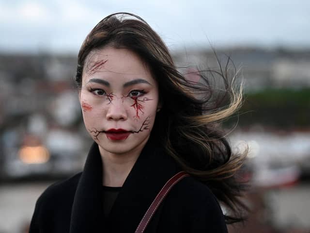 A participant in costume poses for a photograph during the biannual 'Whitby Goth Weekend' festival in Whitby, northern England, on October 31, 2021. - The festival brings together thousands of goths and alternative lifestyle fans from the UK and around the world for a weekend of music, dancing and shopping. (Photo by Oli SCARFF / AFP) (Photo by OLI SCARFF/AFP via Getty Images)