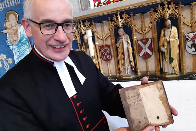 Rev Canon Keith Farrow with the 300 year old book The Faith and Practice of a Church of England Man
