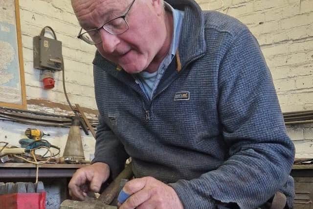 Blacksmith Andrew Renwick, of Ridgeway Forge, is pictured hand-stamping initials onto the links