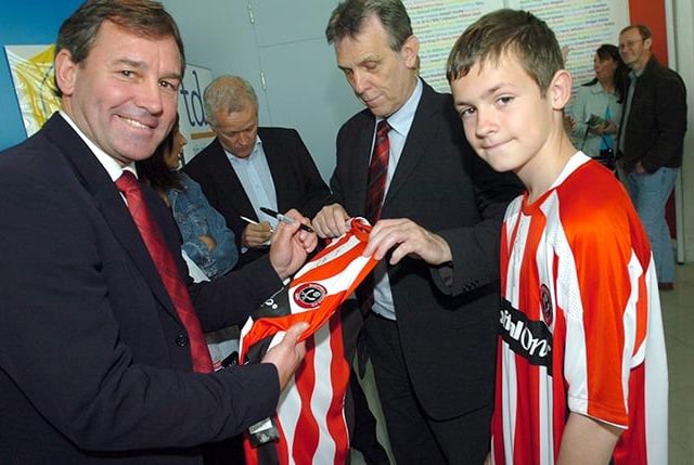 New Sheffield United manager Bryan Robson signs an autograph for United supporter Alex Wilson (11) from Hillsborough, at the 150 Years of Football exibition at the Millennium Galleries, on May 25, 2007