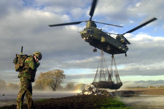 An Army Chinook helicopter drop blocks made from recycled tyres into a breach in the flood defencesnear Howden in East Yorkshire Saturday November 11 2000, as heavy rain continues to swell already swollen rivers across the UK. Soldiers from 150 Transport Rgt (TA) are rebuilding the defences in the area. See PA story WEATHER Floods. PA Photo: Chris Barker/Army