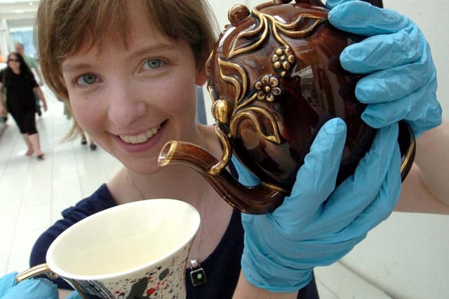 Exhibition Curator Rowena Hamilton with a Cadogan teapot of 1820 and a Pretty Ugly tea cup, 2010 at the Teatopia Exhibition at the Millennium Gallery, Sheffield in June 2010